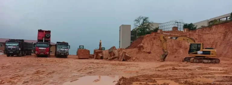 Excavator and dump trucks preparing a building site