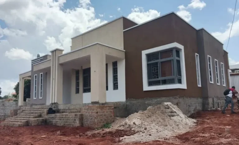 Completed single-storey house with brown and white walls on a Kampala-area plot