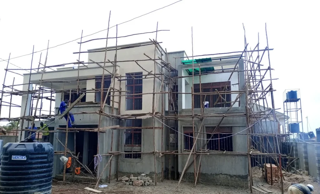 Two-storey house with scaffolding and a water tank on site