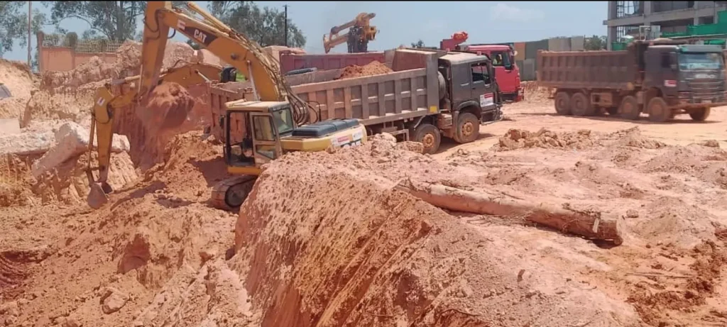 Excavators and tipper trucks working in a deep cut on a large site