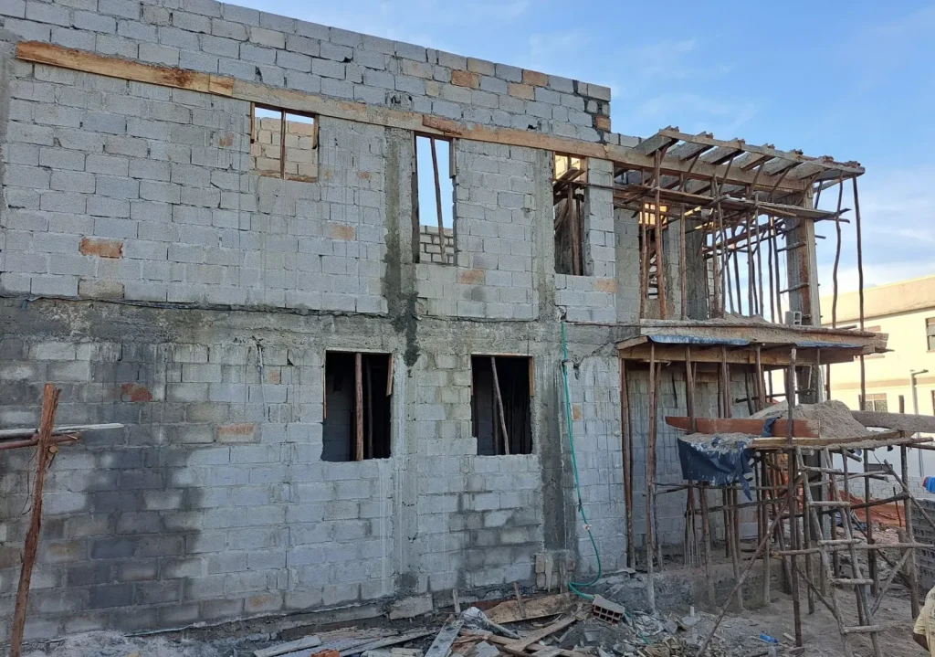 Concrete block walls of a two-storey house with timber formwork on the upper level