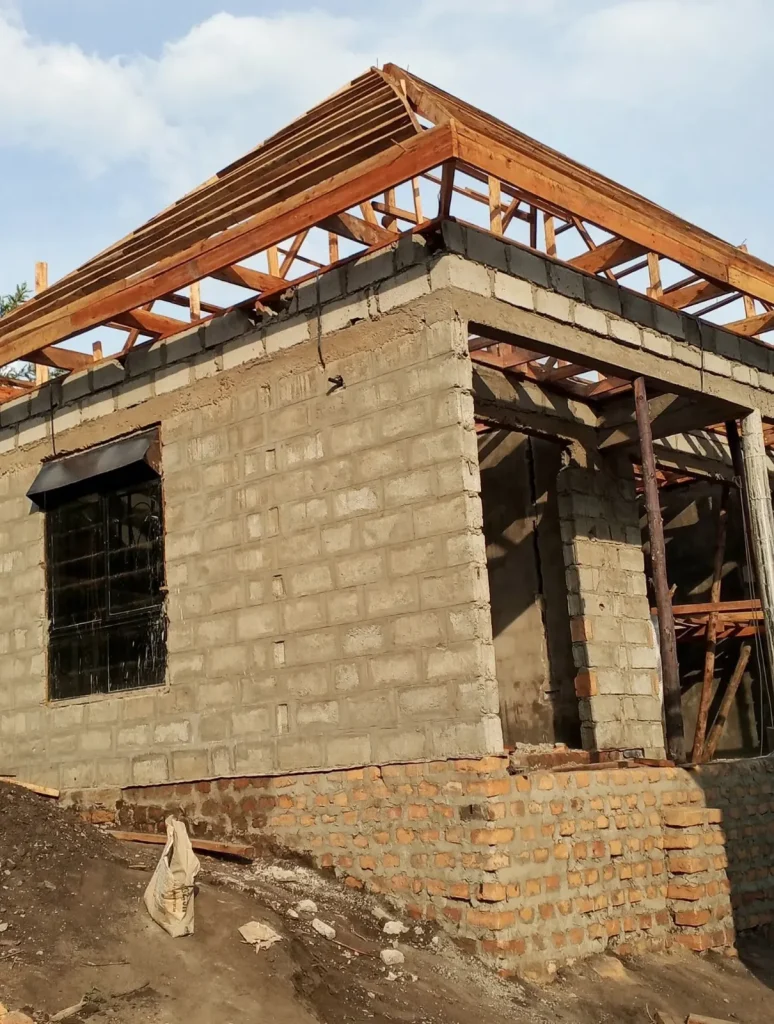 Block and brick house with timber roof trusses and a barred window