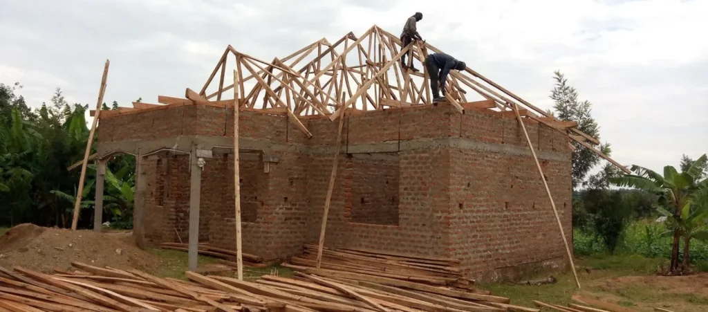 Carpenters fixing timber roof trusses on a brick house