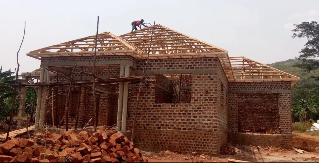 Timber roof trusses on a brick bungalow with a roofer on the ridge