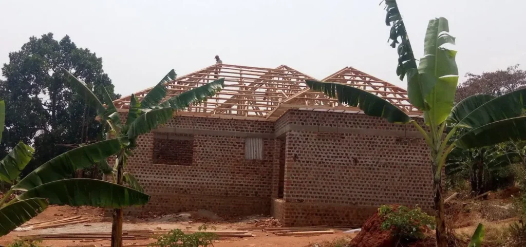 Rear view of a brick house with the timber roof frame complete
