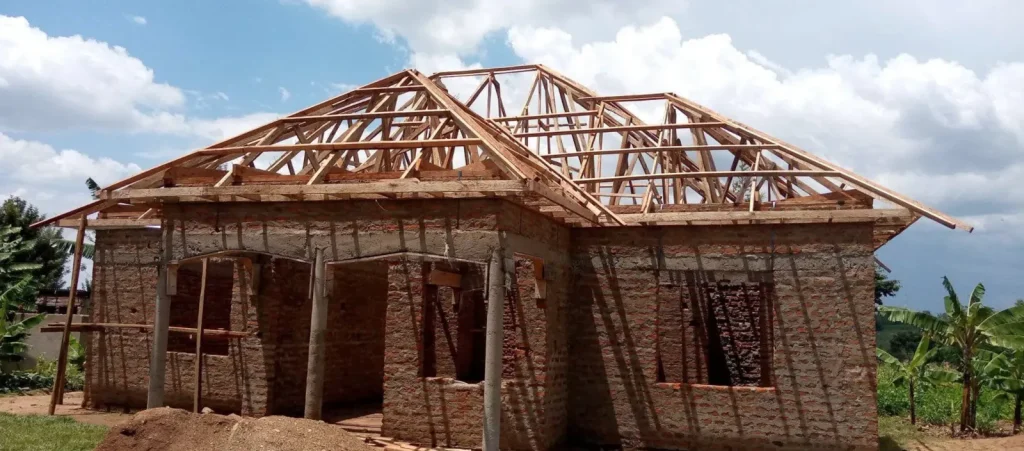 Brick house with a completed timber hip roof frame and a covered front porch